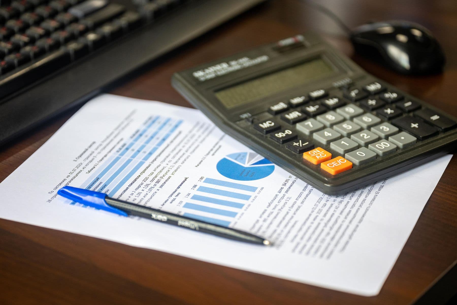 A financial chart and calculator on a desk, representing cost analysis for AI infrastructure spend